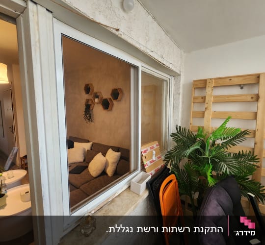 חלון אלומיניום לבן מסוג הזזה המפריד בין הסלון למרפסת